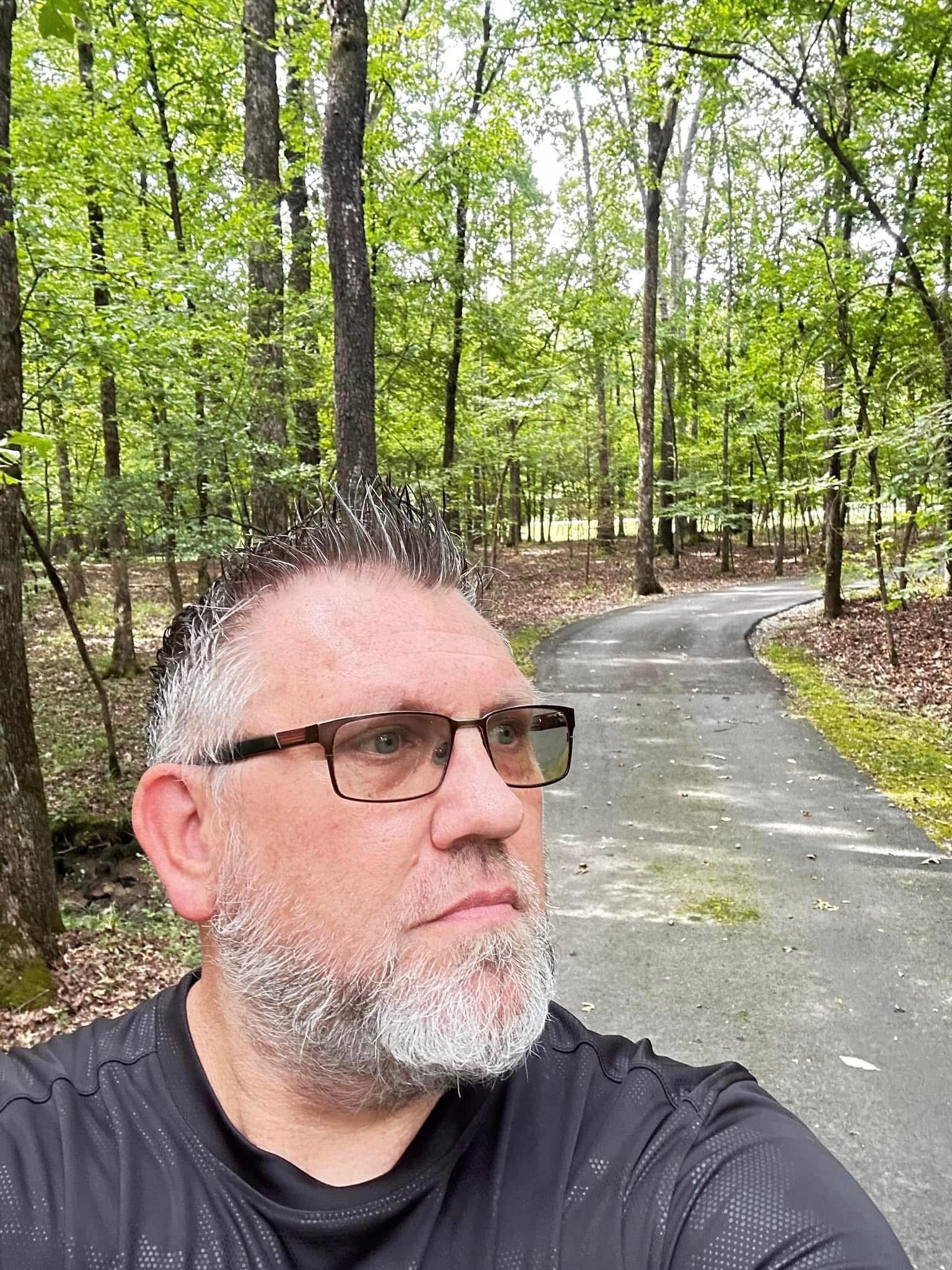 Chuck Dumas walking through a wooded Arkansas trail, reflecting on purpose, growth, and the journey that became Mission Rhyno.