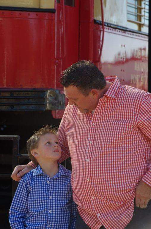 Chuck Dumas sharing a quiet reading moment with his son, reflecting the V3 Rhyno Life commitment to family, learning, legacy, and investing in the next generation.